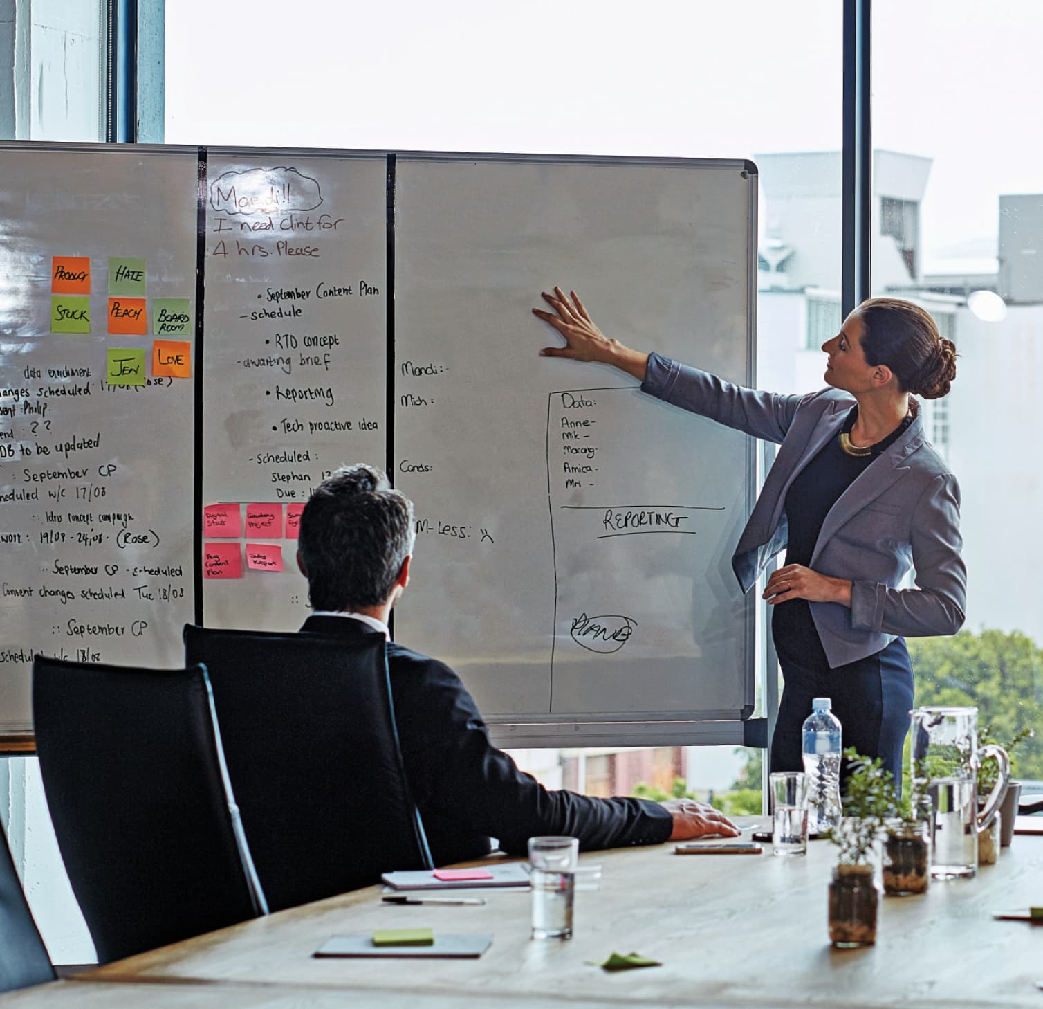 Woman standing by whiteboard in a meeting