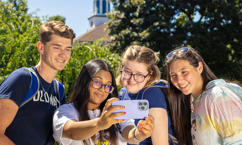 Potential students taking a selfie with a ǿ޴ý student with the ǿ޴ý cupola in the background.